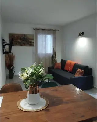 a living room with a table with a vase of flowers at La cave à Papé in Peyriac-de-Mer