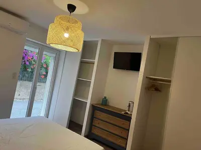 a bedroom with a bed and a television and a window at La cave à Papé in Peyriac-de-Mer