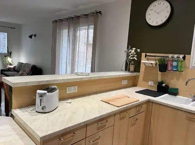 a kitchen with a counter and a clock on the wall at La cave à Papé in Peyriac-de-Mer