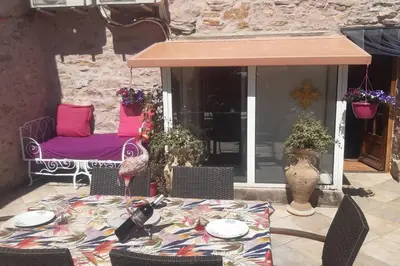 a patio with a table and chairs on a patio at LA PASTOURELLE in Saint-Chinian