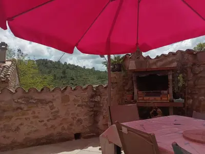 a pink umbrella sitting on top of a table at LA PASTOURELLE in Saint-Chinian