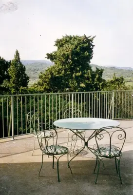 a table and two chairs sitting next to a fence at château de Paulignan in Trausse