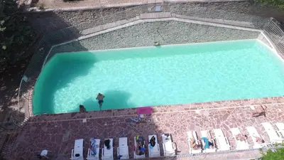 an overhead view of a swimming pool with people in it at château de Paulignan in Trausse