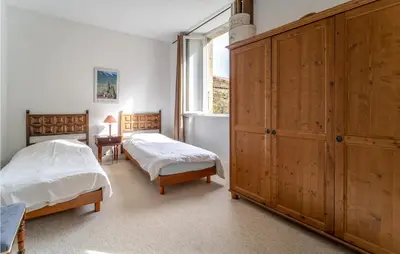 a bedroom with two beds and a large wooden cabinet at Nice Home In Chalabre With Wifi in Chalabre