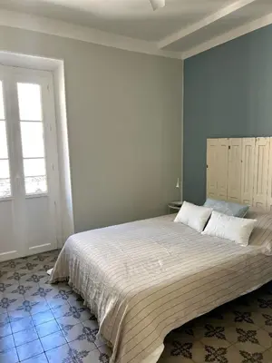 a bedroom with a large bed and a window at Maison Paulette - charme et authenticité in Bizanet