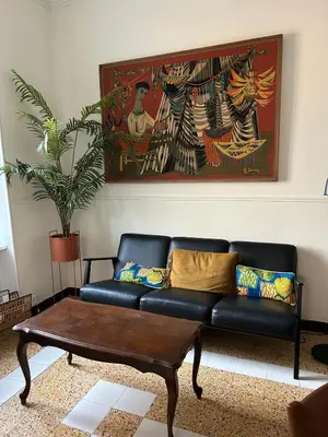 a living room with a black couch and a coffee table at Maison Paulette - charme et authenticité in Bizanet