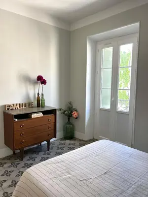 a bedroom with a bed and a dresser and a window at Maison Paulette - charme et authenticité in Bizanet