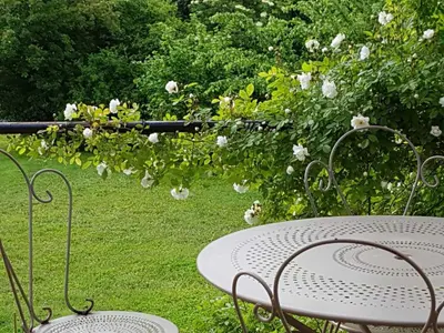 a table and chairs in a garden with flowers at TEMPS de PAUSE - CAMPAGNE in Lautrec