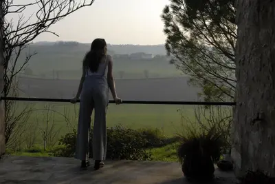 a woman standing on a balcony looking at the view at TEMPS de PAUSE - CAMPAGNE in Lautrec