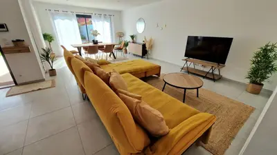 a living room with a couch and a television at L’Oliveraie in Narbonne