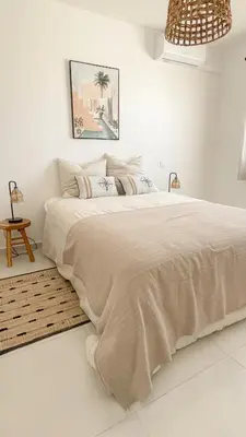 a white bedroom with a large bed in a room at L’Oliveraie in Narbonne