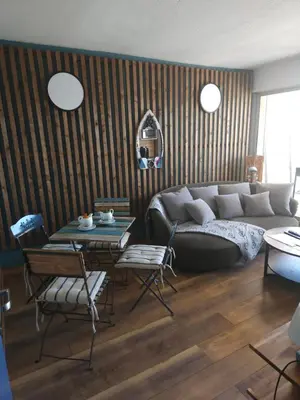 a living room with a couch and a table and chairs at Confort sur le port in Gruissan