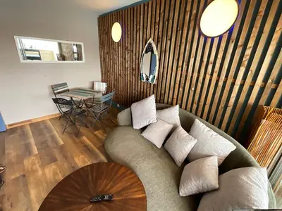 a living room with a couch and a table at Confort sur le port in Gruissan