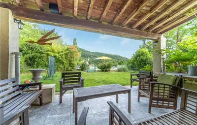 a patio with wooden chairs and tables and a pergola at 1 Bedroom Stunning Home In Chalabre in Chalabre