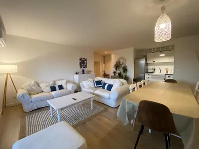a living room with white furniture and a table at T4 bord canal du midi, piscine in Homps
