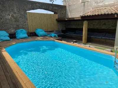 a large swimming pool with blue water in a room at T4 bord canal du midi, piscine in Homps