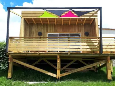 a large wooden house with a large deck at Ferme Bordeneuve in Sonnac-sur-lʼHers