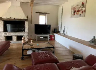 a living room with a couch and a tv at Ferme Bordeneuve in Sonnac-sur-lʼHers