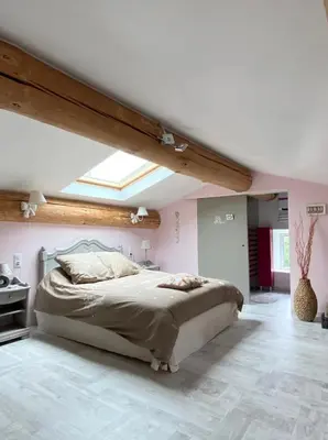 a bedroom with a large bed in a attic at Ferme Bordeneuve in Sonnac-sur-lʼHers