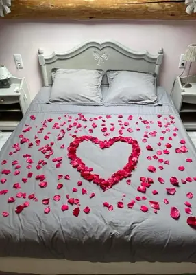 a bed with a heart made out of red roses at Ferme Bordeneuve in Sonnac-sur-lʼHers