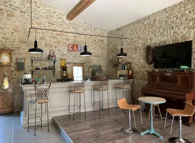 a bar with chairs and a piano in a room at Ferme Bordeneuve in Sonnac-sur-lʼHers