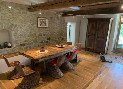 a dining room with a wooden table and chairs at Ferme Bordeneuve in Sonnac-sur-lʼHers