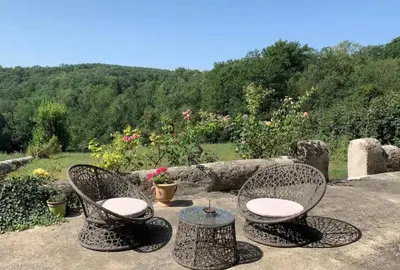 a patio with two chairs and a table at Ferme Bordeneuve in Sonnac-sur-lʼHers