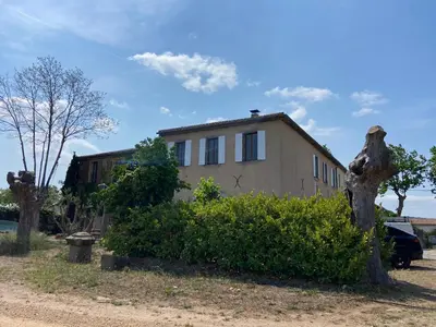 a house with a tree stump in front of it at T2 bord du canal du midi piscine in Homps