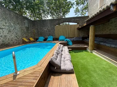 a swimming pool with a deck and a grass yard at T2 bord du canal du midi piscine in Homps