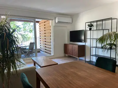 a living room with a table and a television at T2 bord du canal du midi piscine in Homps