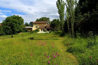 a house in the middle of a field with pink flowers at Domaine du Bourdil au pays Cathare in Chalabre