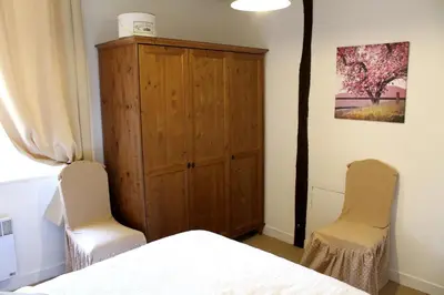 a bedroom with two chairs and a wooden cabinet at Domaine du Bourdil au pays Cathare in Chalabre
