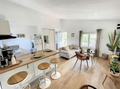 a living room with a couch and a table and chairs at Les pénates du pastel - Jardin & Terrasse in Villefranche-de-Lauragais