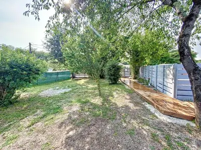 a yard with two trees and a fence at Les pénates du pastel - Jardin & Terrasse in Villefranche-de-Lauragais