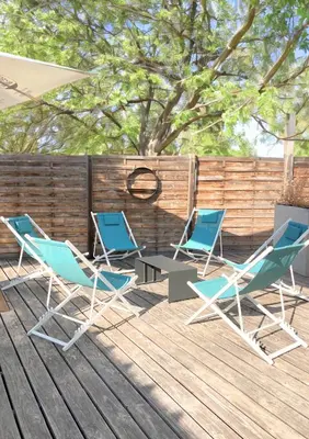 three chairs and a table on a deck at Domaine de la Palme in Lapalme