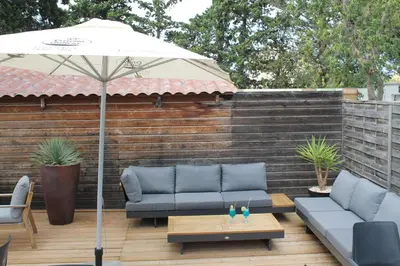 a patio with couches and an umbrella and a table at Domaine de la Palme in Lapalme