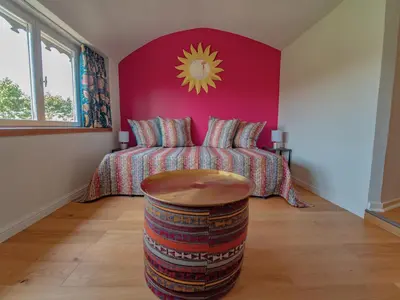 a bedroom with a bed with a pink wall at Clos des Oliviers in Mirepoix