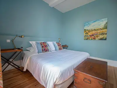 a bedroom with a bed and a painting on the wall at Clos des Oliviers in Mirepoix