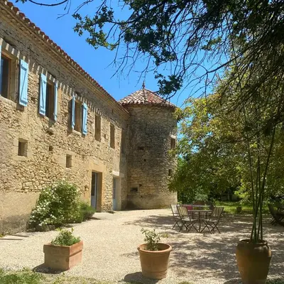 a building with a table and chairs in a courtyard at Souplassens in Rieumajou