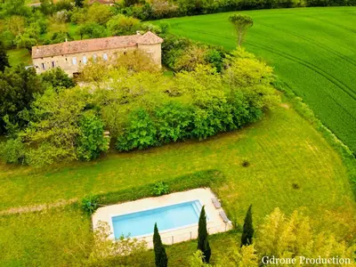 an aerial view of a house and a swimming pool in a field at Souplassens in Rieumajou