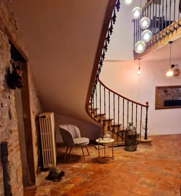 a living room with a staircase and a chair at L'écrin in Lacroisille