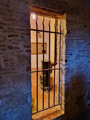 an iron barred window in a room with a fire hydrant at L'écrin in Lacroisille