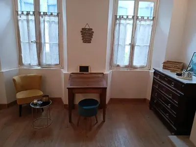 a desk and chair in a room with windows at L'écrin in Lacroisille