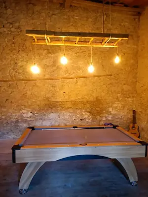 a ping pong table in a room with a ceiling at L'écrin in Lacroisille