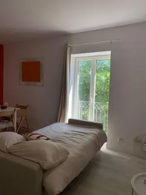 a bedroom with a bed and a large window at Appartement cœur de village Numéro1 in Peyriac-de-Mer