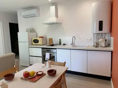a kitchen with a table with a plate of fruit on it at Appartement cœur de village Numéro1 in Peyriac-de-Mer