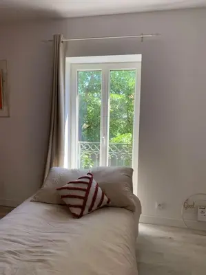 a bed with a pillow in front of a window at Appartement cœur de village Numéro1 in Peyriac-de-Mer