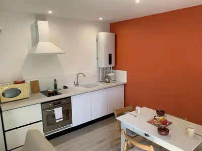 a kitchen with a table and a sink and a microwave at Appartement cœur de village Numéro1 in Peyriac-de-Mer