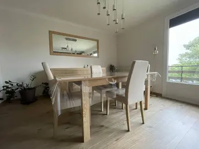 a dining room with a table and chairs and a mirror at Appartement 2 chambres +parking in Narbonne