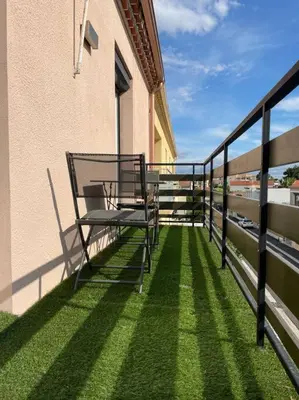 a balcony with a bench on the side of a building at Appartement 2 chambres +parking in Narbonne